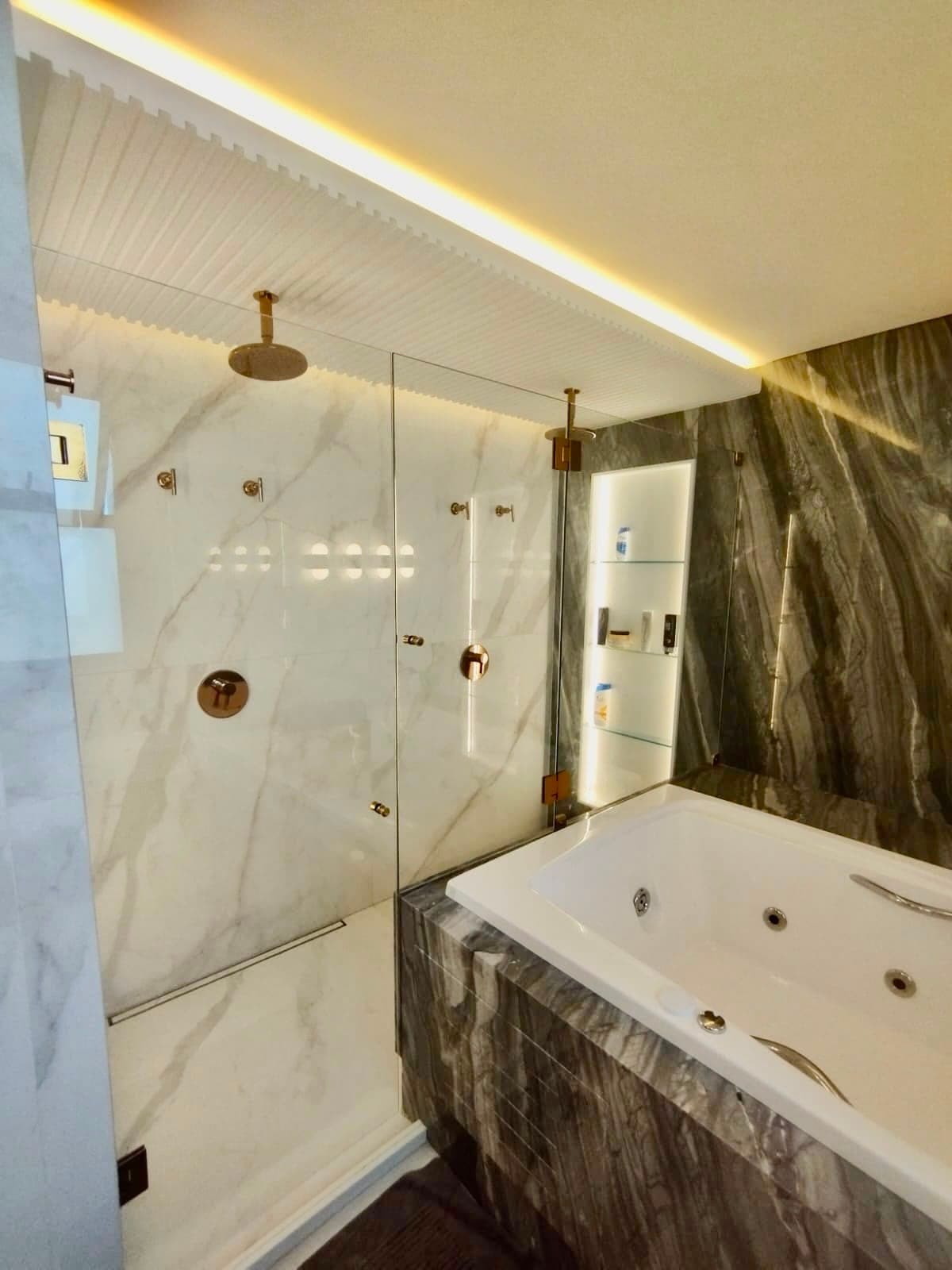 Banheiro com box de vidro e mármore escuro